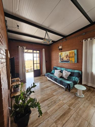 a living room with a green couch and a table at Rancho Cata Vento in Santa Clara dʼOeste