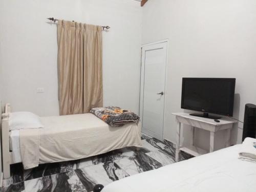 a room with two beds and a flat screen tv at The cabin in La Esperanza, Intibúca in Intibucá