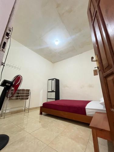a bedroom with a bed and a chair in a room at 55 Ketapang Homestay in Ketapang