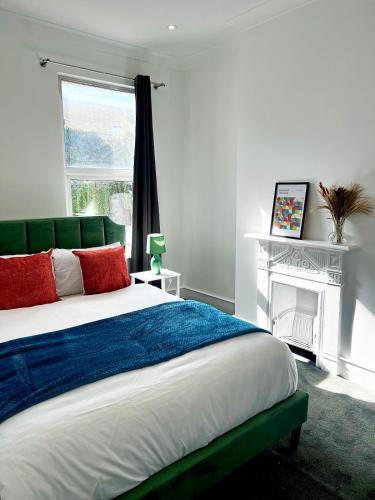 a bedroom with a large bed and a fireplace at Spacious 4Bedroom - 10mins to London Bridge with Parking & Garden in London