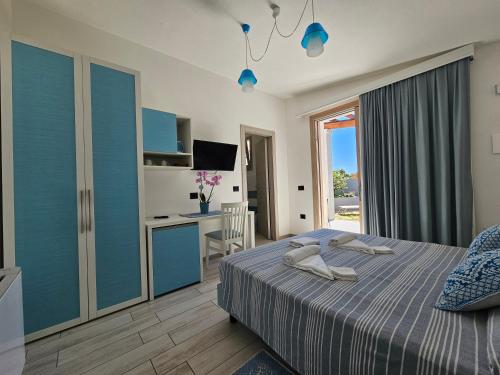 a bedroom with a bed and a desk with a computer at Hotel Pranos Turismo Rurale Cala Gonone in Cala Gonone