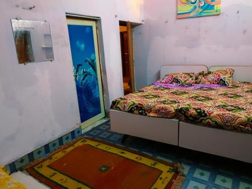 a bedroom with a bed and a rug on the floor at Kanchan Lata Homestay in Banāras Cantonment