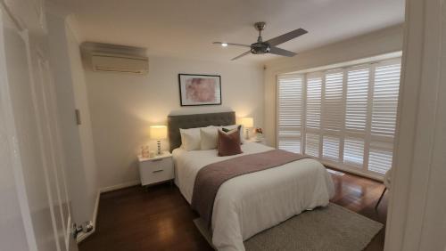 a bedroom with a bed and a ceiling fan at Seffa Dom property Melbourne in Springvale South