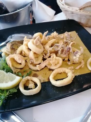 a plate of shrimp with a lemon and lettuce at Hotel Poseidonia in Sapri
