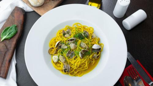 a plate of pasta with mussels on a table at InterContinental Santiago by IHG in Santiago