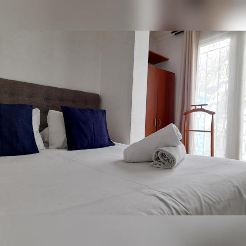 a bed with blue and white pillows at Atacama Hostel Backpackers in Santiago