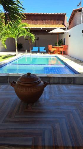 a pool with a pot sitting on the ground next to a house at Casa Simões in Fortim
