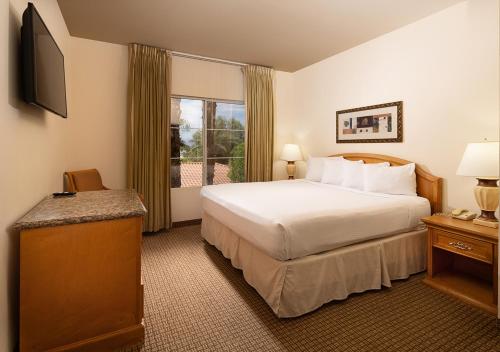 a hotel room with a bed and a window at Club de Soleil All-Suite Resort in Las Vegas