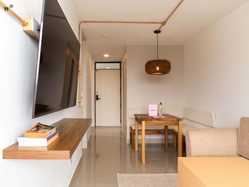 a small living room with a table and a television at Hotel Santa Ana Medellin in Medellín
