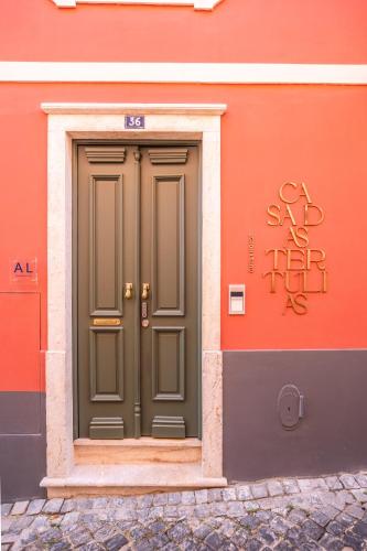 a green door on the side of a building at Casa das Tertúlias in Leiria