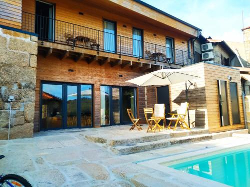 a house with a patio and a swimming pool at Grandmother Custódia's House Gerês in Campo do Gerês