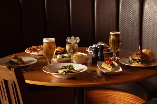 a table with plates of food and glasses of beer at Portrush Atlantic Hotel in Portrush