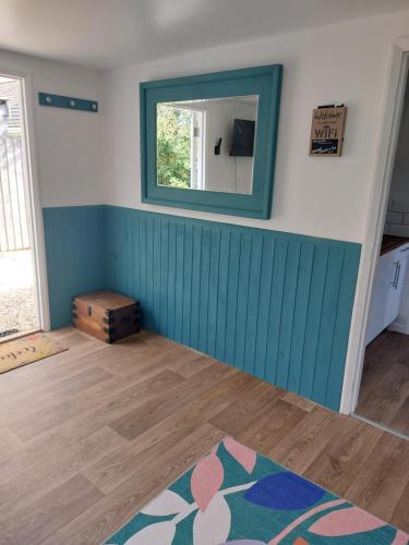 a room with a mirror and a wooden floor at The Garden Room at Poplar Cottage - Weston-super-Mare in Wick Saint Lawrence