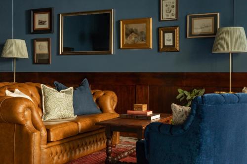 a living room with a leather couch and two chairs at Portrush Atlantic Hotel in Portrush