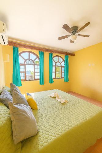 a bedroom with a large bed with blue curtains at Zihua 6bed 3bath Home for 12 with Direct Access to Beach in Zihuatanejo
