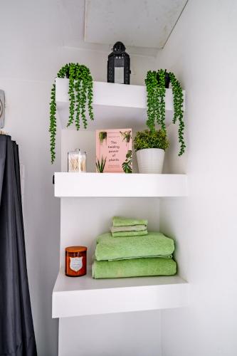a room with white shelves with plants and green towels at Short North Convention Private Parking Pets in Columbus