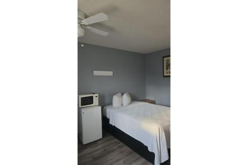 ローズバーグにあるHotel O Motel 10 Lordsburg I-10のベッドと天井扇風機のある寝室