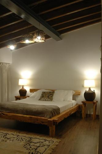 a bedroom with a large bed with two lamps at Casa de l Telar in Duas Igrejas