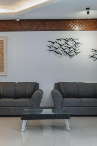 a living room with two couches and a coffee table at Hotel Plaza Kokai Cancún in Cancún