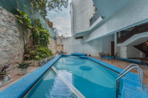 a large blue swimming pool next to a building at Hotel Plaza Kokai Cancún in Cancún