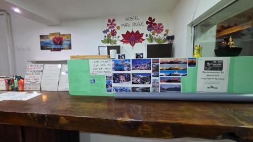 un mostrador en una habitación con fotos en la pared en Hostel Mapu Paigue, en El Chaltén