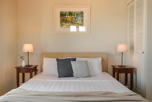 a bedroom with a large bed with two nightstandiatesiatesiatesiatesiatesiates at Ruggero by Vintage Travel in Psilithriás