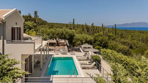 a villa with a swimming pool and a view of the ocean at Ruggero by Vintage Travel in Psilithriás