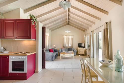 a kitchen and living room with red cabinets at Ruggero by Vintage Travel in Psilithriás