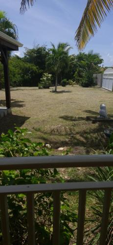 a view of a yard from a porch at Villa le flamboyant in Le Marin