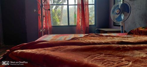 1 dormitorio con 1 cama con ventana y manta en Misty mount, en Madikeri