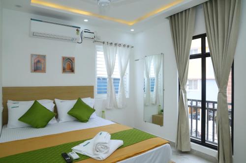 a bedroom with a bed and a large window at Hotel Aeroview Near Chennai Airport in Chennai