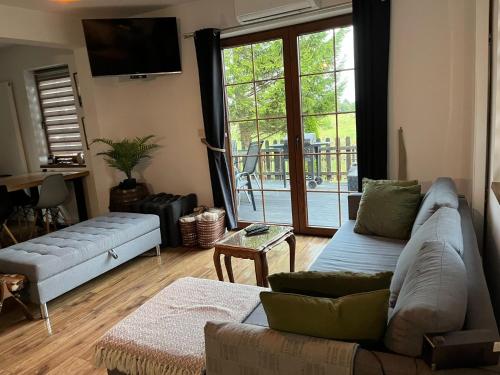 a living room with a couch and a sliding glass door at Dom Na Wsi in Mierzwin Duży