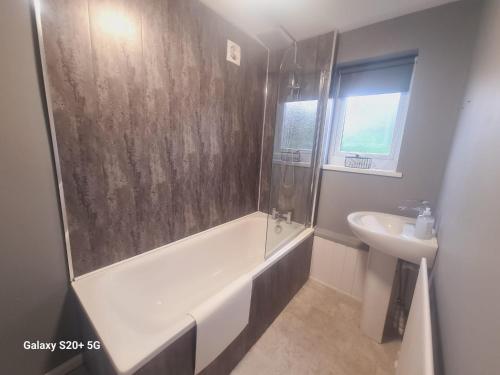 サウス・シールズにあるModern 3 bed Houseのシャワー、浴槽、洗面台を備えたバスルーム