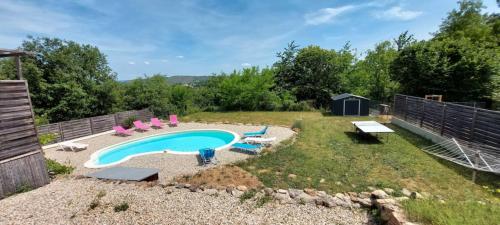 un patio trasero con piscina, sillas y una valla en Villa Loumapé, en Ribes