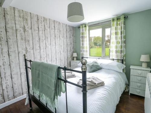 a bedroom with a bed and a window at Harbour Lights in Holyhead
