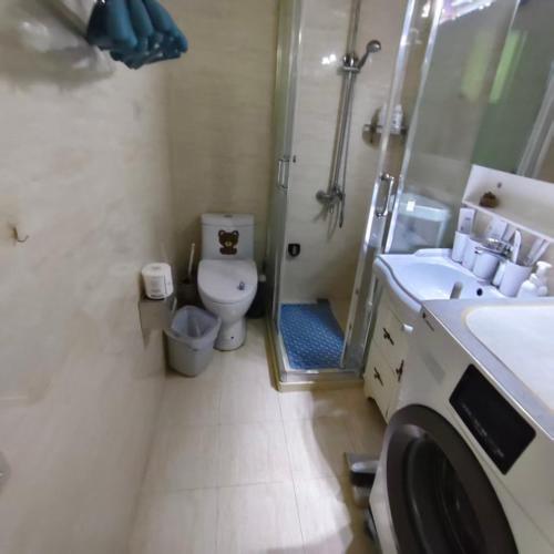 a bathroom with a toilet and a shower and a sink at Book and Bed-People's Square in Shanghai