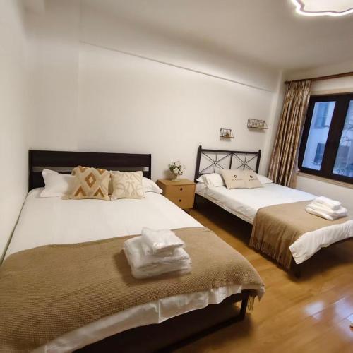 a bedroom with two beds and a window at Book and Bed-People's Square in Shanghai