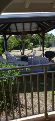 a table and chairs on top of a porch at Villa le flamboyant in Le Marin