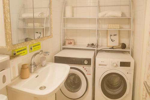Un baño con lavadora y lavabo. en Theano's Cozy & Quiet Lux Central Flat - Wifi & full Amenities, en Patra