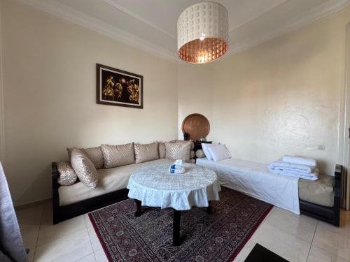ein Wohnzimmer mit Sofa und Tisch in der Unterkunft Apartement Bab lhad in Rabat