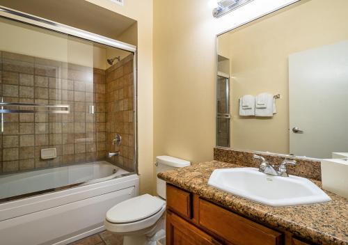 a bathroom with a sink and a toilet and a tub at Club de Soleil All-Suite Resort in Las Vegas