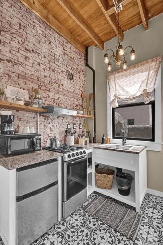 a kitchen with white appliances and a brick wall at Cozy Casa Mina 1br Near Downtown Parking in El Paso