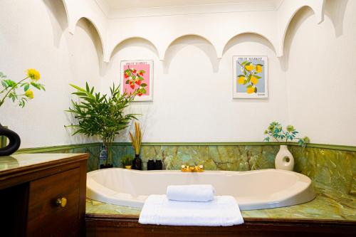 eine Badewanne in einem Badezimmer mit Waschbecken in der Unterkunft Bright & Spacious 5-Bedroom Stay near Cambridge in Hardwick