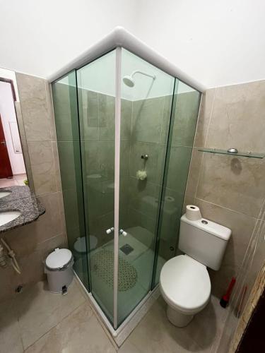 a bathroom with a toilet and a glass shower at Casa Simões in Fortim