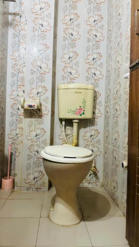 a bathroom with a toilet in a room with wallpaper at Hotel New Royal Palace Dhanmondi in Dhaka
