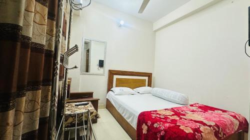 a small bedroom with a bed and a mirror at Hotel New Royal Palace Dhanmondi in Dhaka