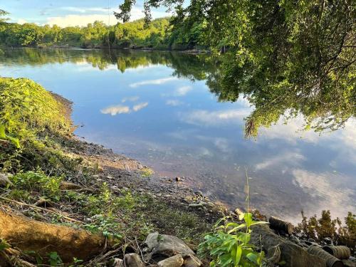 een rivier met een weerspiegeling van de lucht in het water bij โฮมสเตย์ติดแม่น้ำปิง in Sam Ngao