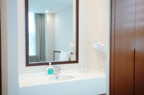 a bathroom with a sink and a mirror at Rosana Hotel in Seoul