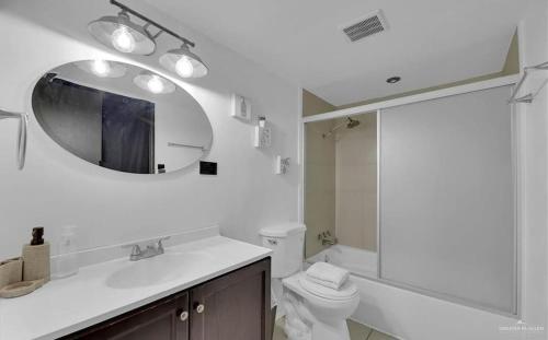 a bathroom with a sink and a mirror and a toilet at Charming 1BR Condo Near UTRGV & Downtown Edinburg in Edinburg