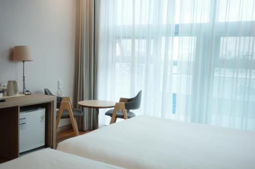 a hotel room with a bed and a table and a window at Rosana Hotel in Seoul